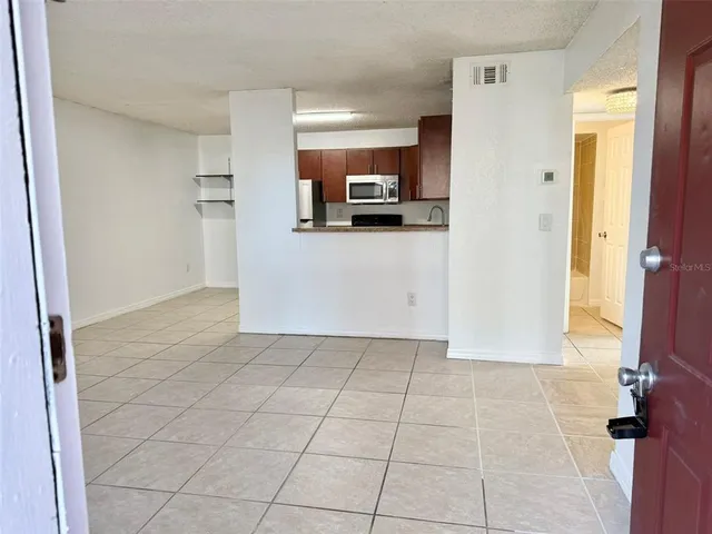a kitchen with granite countertop a refrigerator and a sink