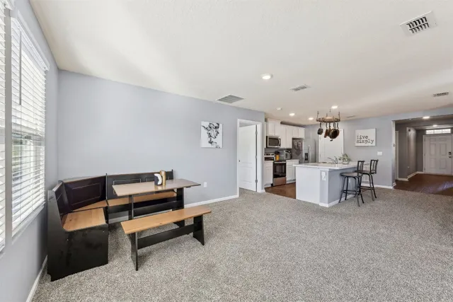 a kitchen with stainless steel appliances granite countertop a stove a sink and a microwave