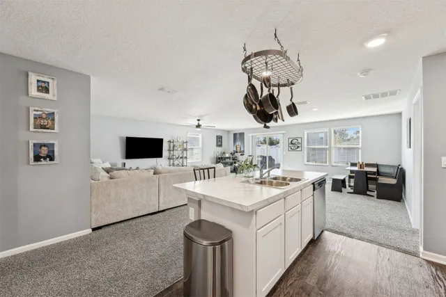 a kitchen with stainless steel appliances granite countertop a sink a stove and cabinets