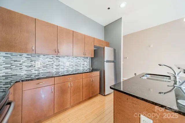a kitchen with stainless steel appliances granite countertop a sink and cabinets