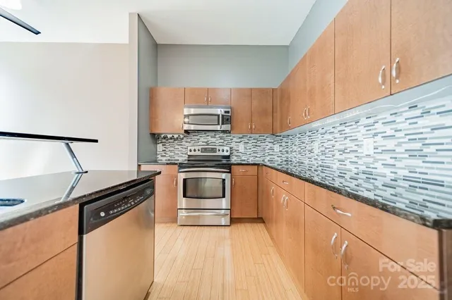 a kitchen with granite countertop a sink stove and cabinets