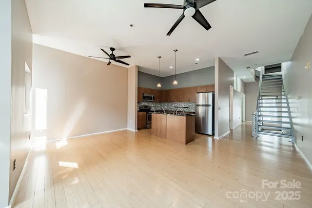 a view of empty room with wooden floor and ceiling fan