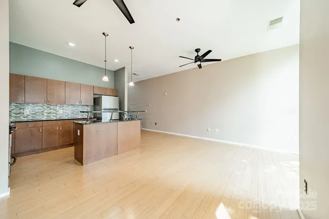 a view of kitchen with stainless steel appliances granite countertop white cabinets and granite counter tops