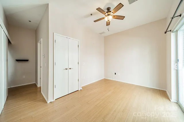 a view of a big room with closet and a chandelier fan