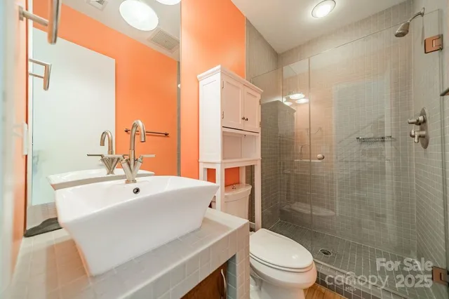 a bathroom with a sink a toilet and shower