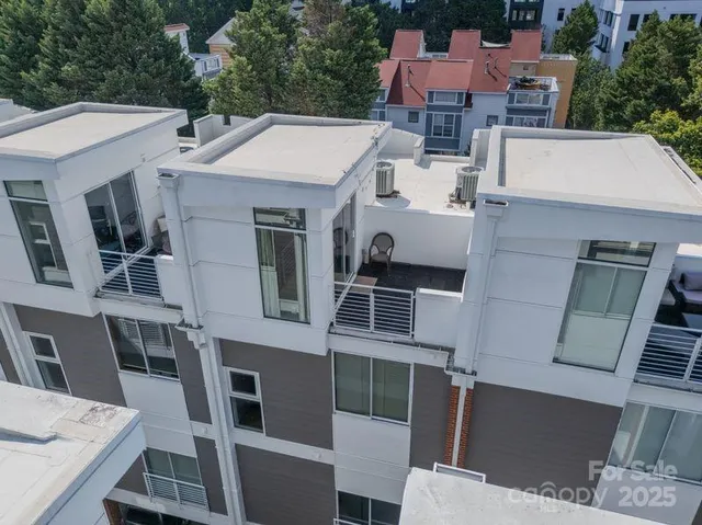 an aerial view of residential houses with outdoor space and parking