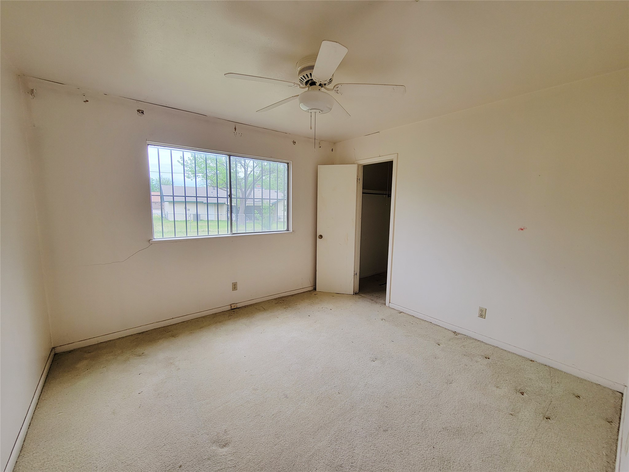 6605 Highpoint Drive Austin, TX 78723 - Photo 10 of 11 Carpeted room featuring a ceiling fan and a window with security bars