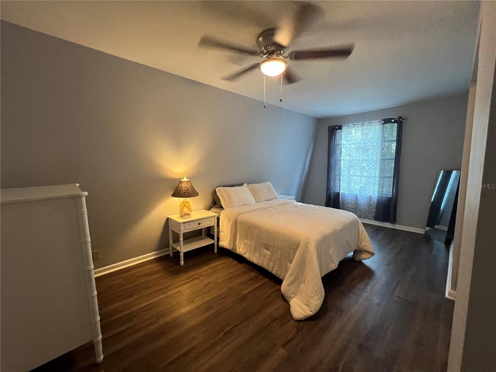 15024 Northwest 89th Street Alachua, FL 32615 - Photo 12 of 16 a bedroom with a bed and a chandelier
