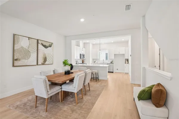 a large white kitchen with a stove a sink dishwasher and a fireplace with wooden floor