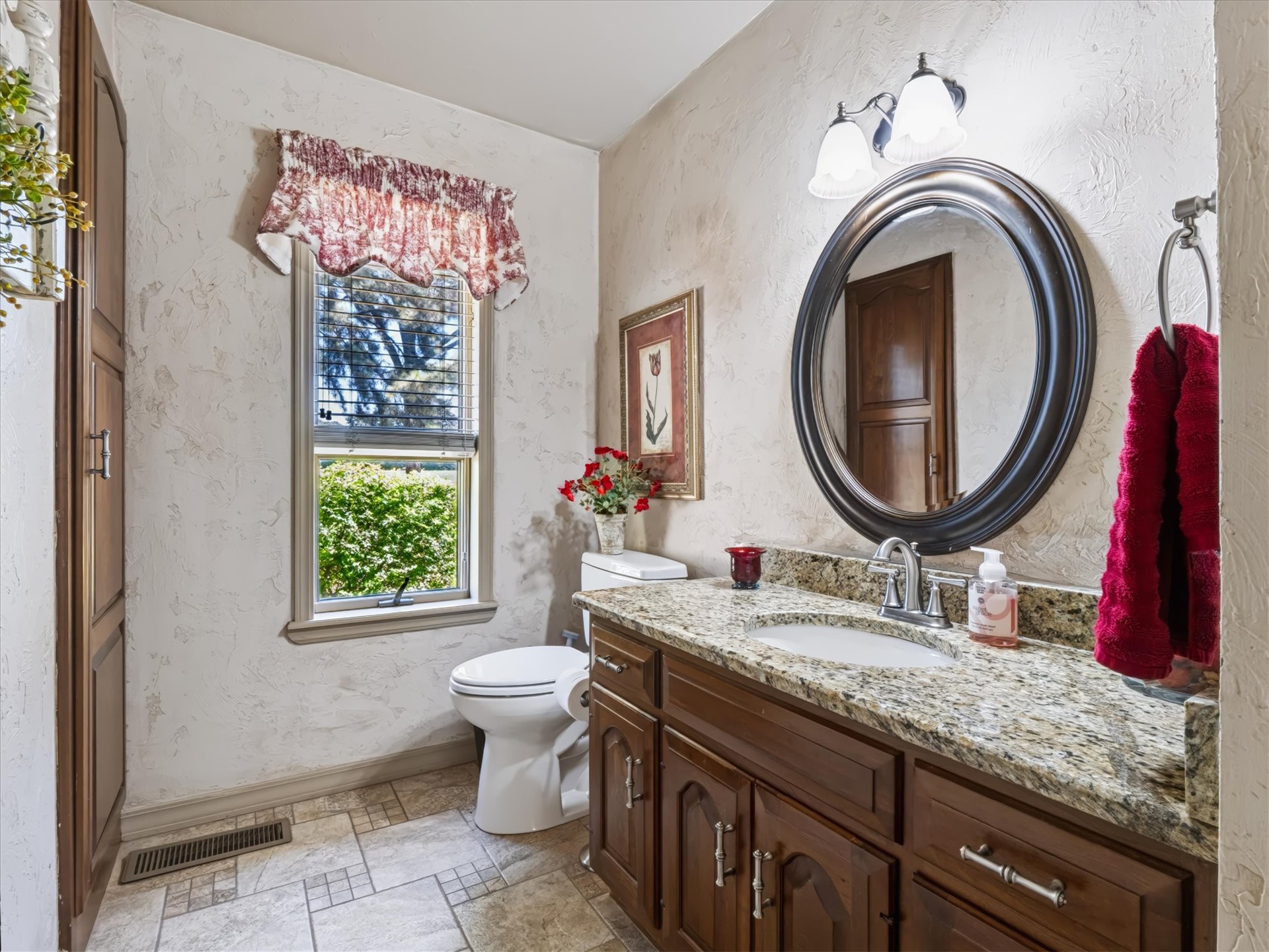 1133 West Chicken Fight Road Atoka, OK 74525 - Photo 27 of 49 Wood-finish vanity with an undermount sink, stone countertop, and an oval mirror
