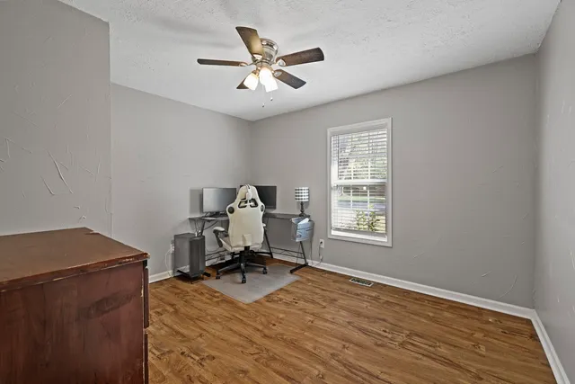 a view of a workspace with furniture and a window
