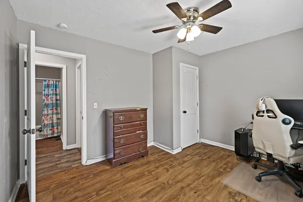 a view of a bedroom with cabinet and a ceiling fan