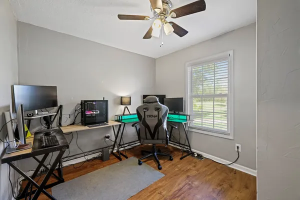 a view of a workspace with furniture and a window