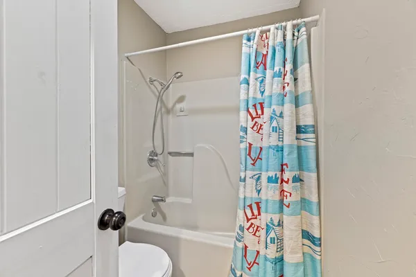 a bathroom with a bathtub and a shower curtain