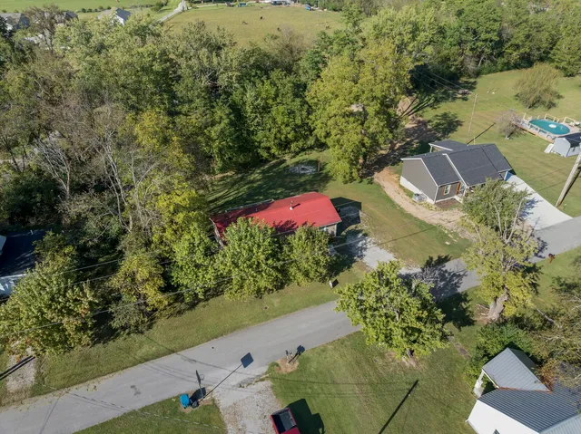 an aerial view of residential house with yard and swimming pool