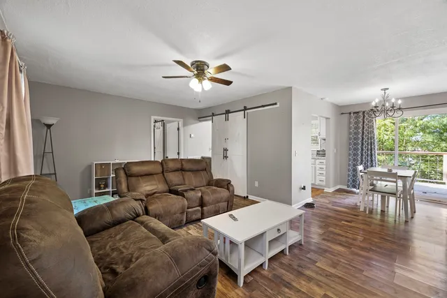 a living room with furniture a wooden floor and a window