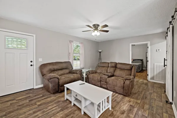 a living room with furniture and a wooden floor