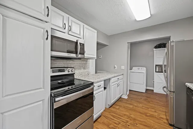 a kitchen with stainless steel appliances a stove microwave and cabinets