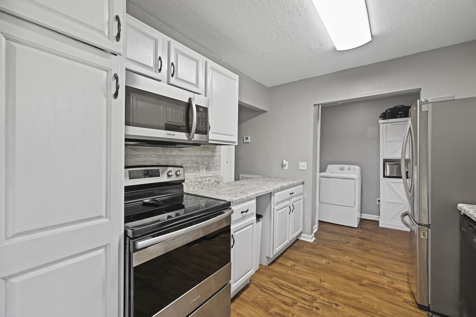 408 Magnolia Street Baxter, TN 38544 - Photo 10 of 44 a kitchen with stainless steel appliances a stove microwave and cabinets