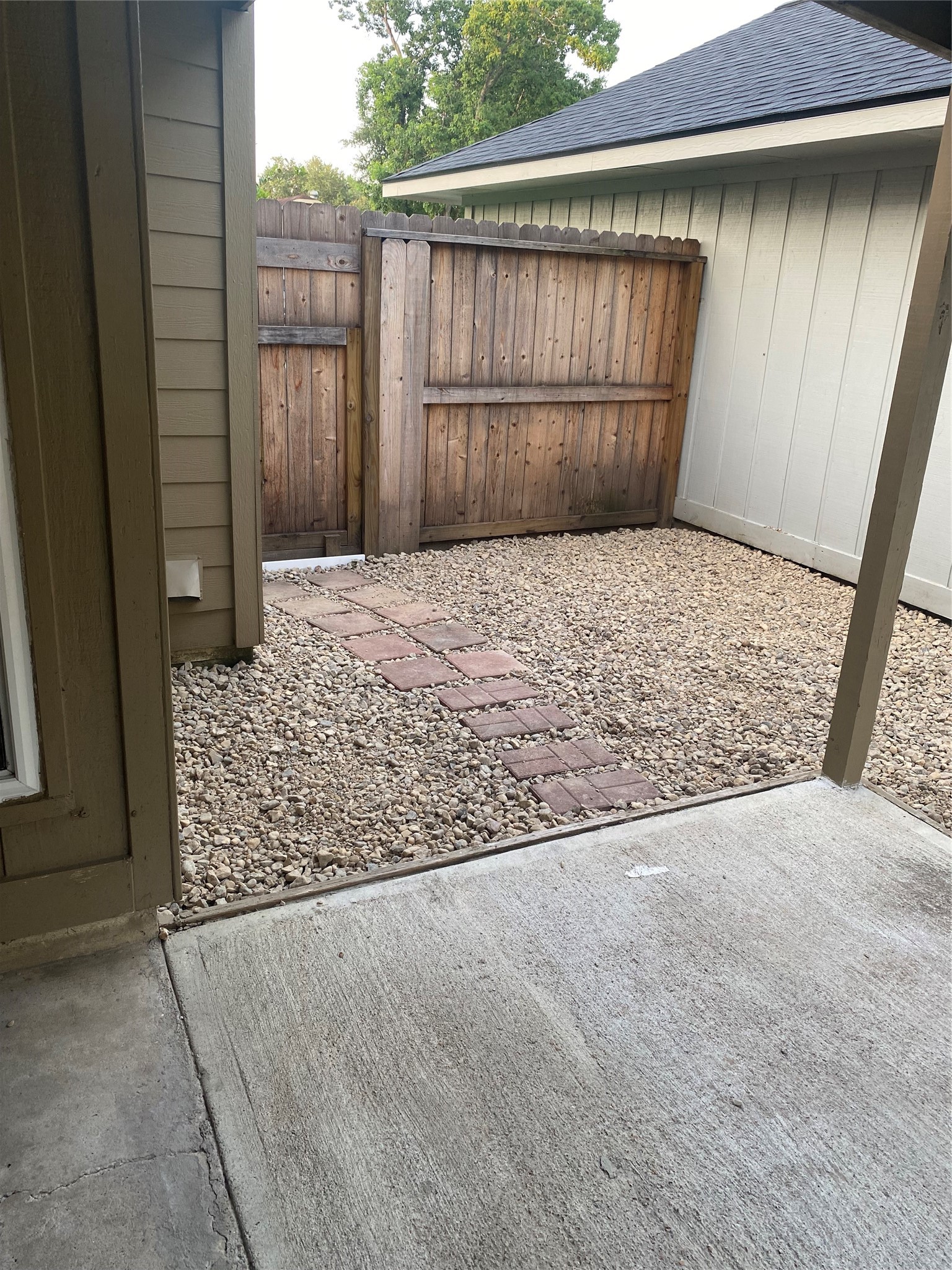 3107 Raccoon Run Spring, TX 77373 - Photo 6 of 35 Picture angle from back patio showing pebble rocks and privacy fence and gate
