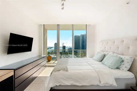 a bedroom with a bed and a flat screen tv