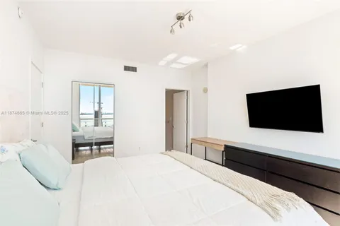 a bedroom with a bed and a flat screen tv