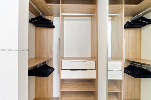 a view of walk in closet with clothes and shoes