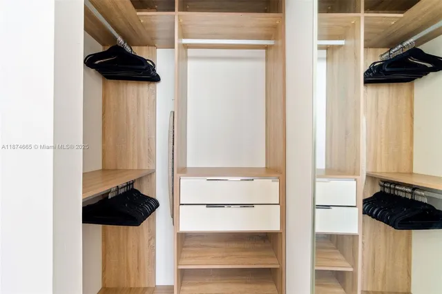 a view of walk in closet with clothes and shoes