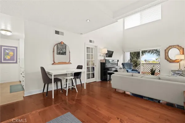 a living room with furniture dining table and wooden floor