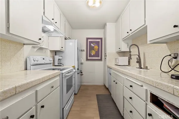 a kitchen with cabinets a sink and appliances