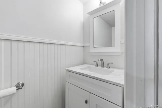 a bathroom with a sink vanity and a mirror