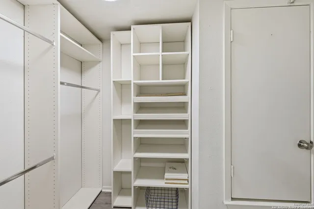a view of walk in closet with empty racks