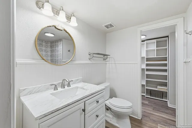 a bathroom with a toilet sink and mirror