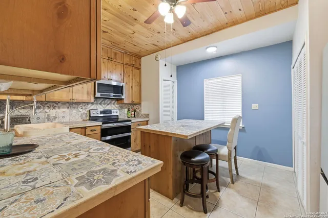 a kitchen with a stove a refrigerator and a dining table