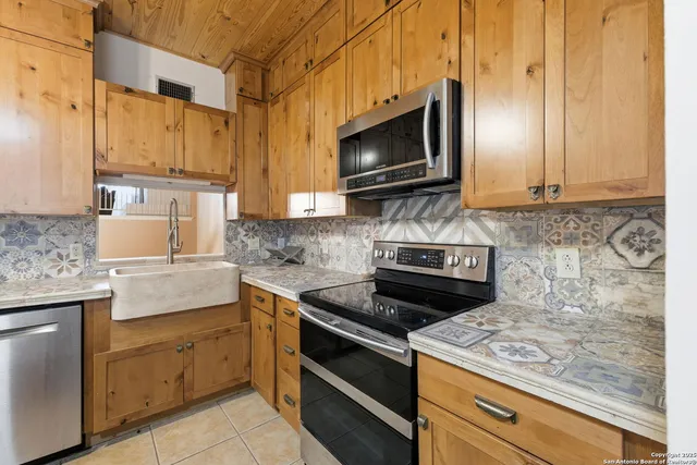 a kitchen with stainless steel appliances granite countertop a sink stove and microwave