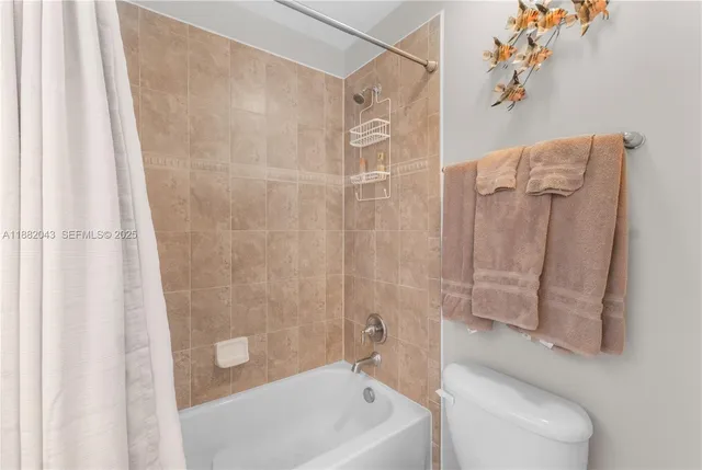 a view of a white house next to a yard with plants and trees