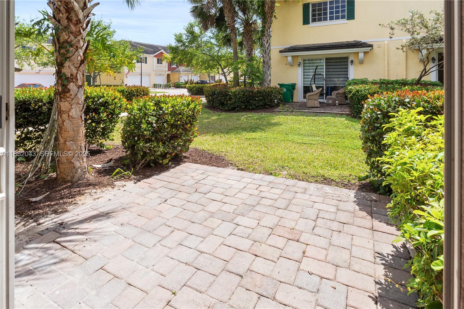 7702 Paddock Place, Unit 7702 Davie, FL 33328 - Photo 22 of 55 a view of a white house next to a yard with plants and trees