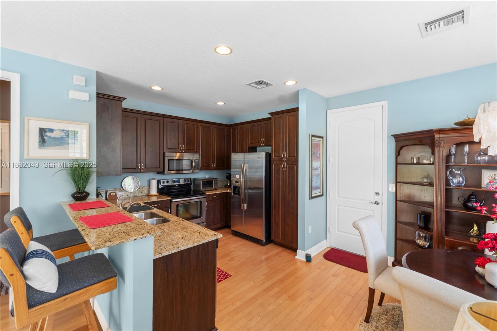 7702 Paddock Place, Unit 7702 Davie, FL 33328 - Photo 33 of 55 a kitchen that has a lot of cabinets and refrigerator in it