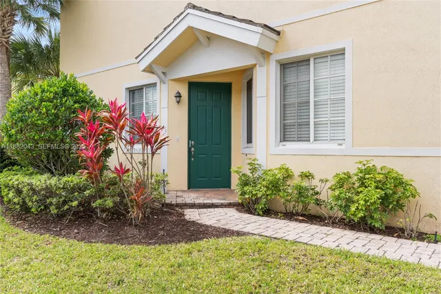 a front view of a house with a garden and plants