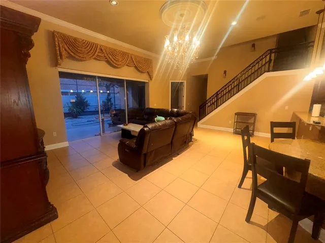 a living room with couches and kitchen view with wooden floor