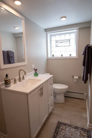 a bathroom with a sink a toilet and mirror