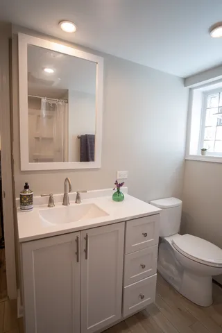 a bathroom with a toilet sink and mirror