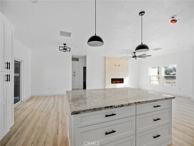 a view of an empty room with a fireplace and a window