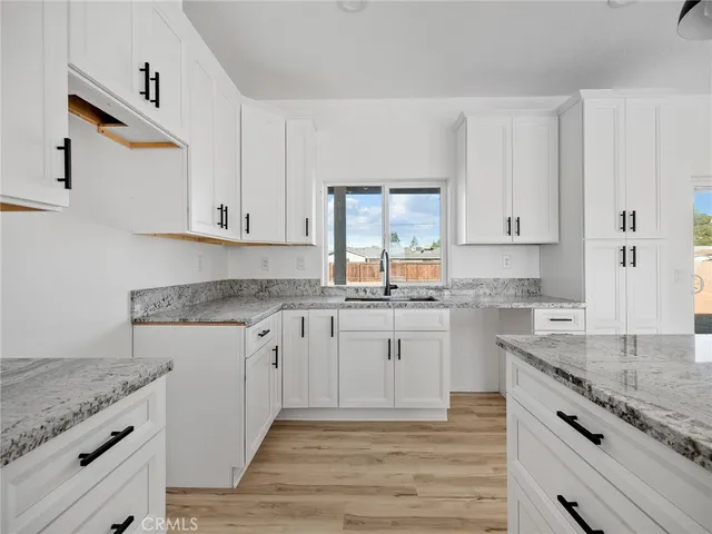 a kitchen with granite countertop cabinets stainless steel appliances and a counter space