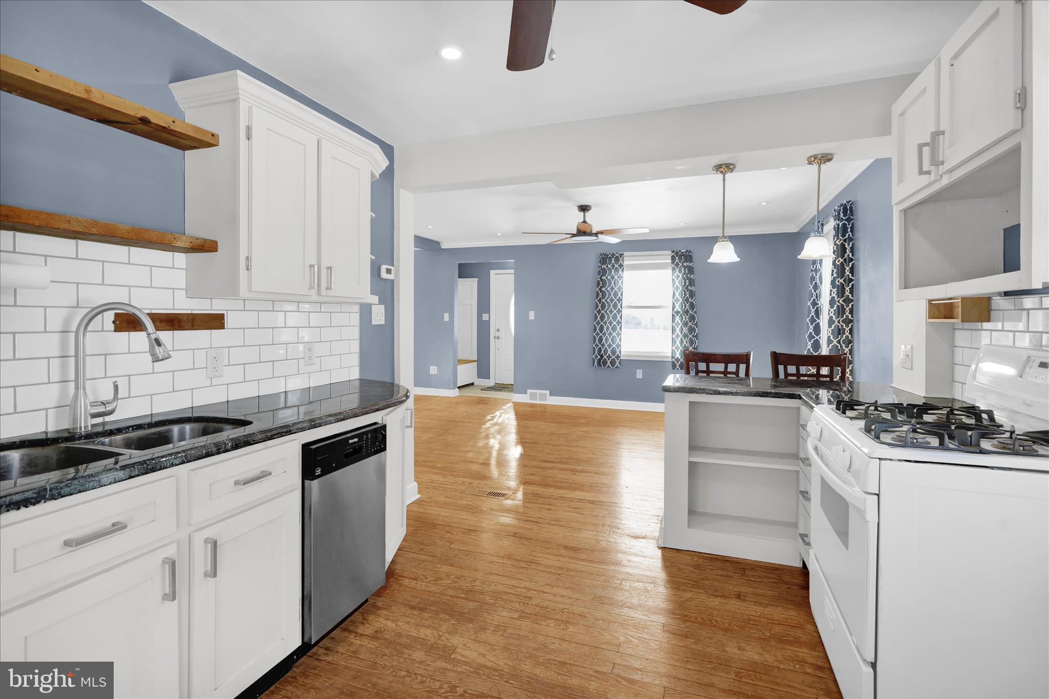 821 Bellefonte Avenue Reading, PA 19607 - Photo 8 of 37 a large white kitchen with kitchen island a sink a stove and wooden floors