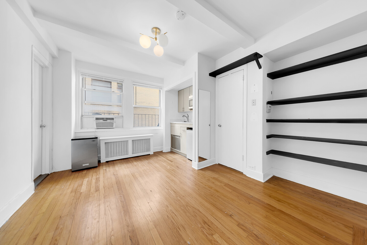 321 East 43rd Street, Unit 607 Manhattan, NY 10017 - Photo 2 of 7 a view of an empty room with a window and wooden floor