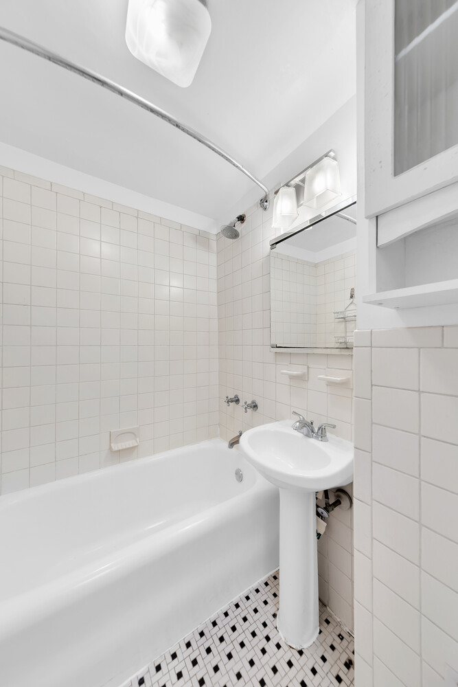 321 East 43rd Street, Unit 607 Manhattan, NY 10017 - Photo 4 of 7 a bathroom with a sink a toilet and shower