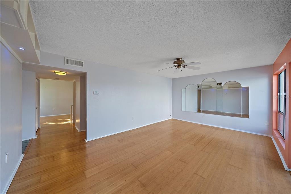 6157 Midnight Pass Road, Unit B12 Sarasota, FL 34242 - Photo 11 of 75 a view of an empty room with wooden floor and a ceiling fan