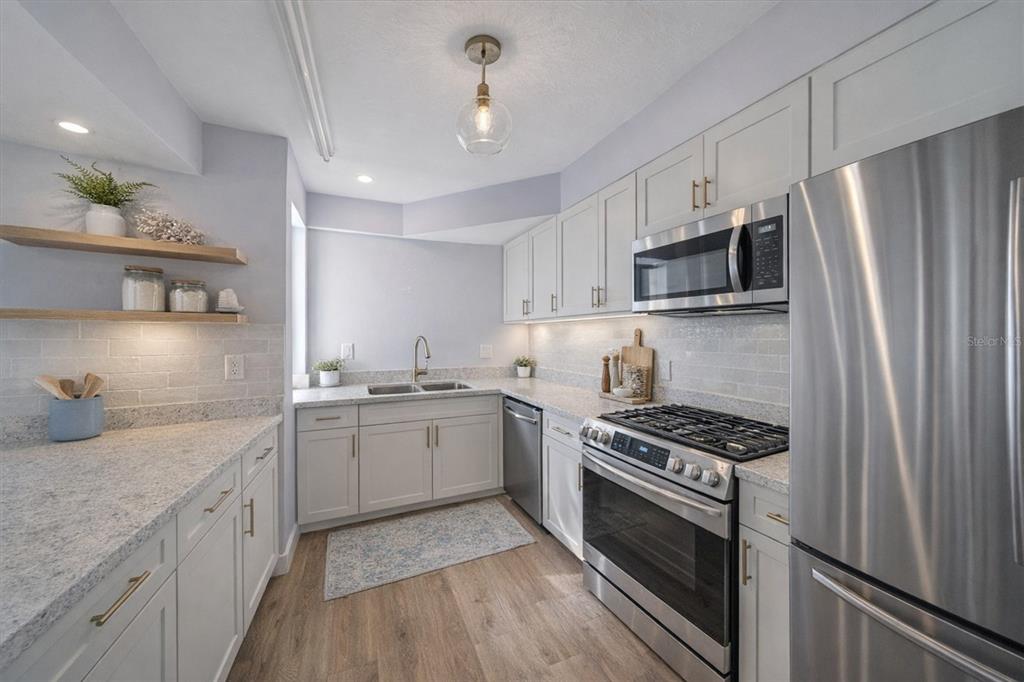 6157 Midnight Pass Road, Unit B12 Sarasota, FL 34242 - Photo 23 of 75 a kitchen with stainless steel appliances a sink stove and refrigerator