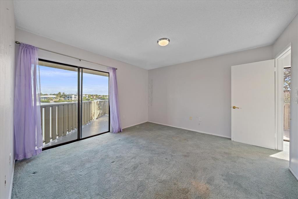 6157 Midnight Pass Road, Unit B12 Sarasota, FL 34242 - Photo 30 of 75 an empty room with sliding glass door and mountain view